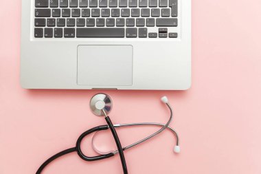 Pembe arka plan üzerinde izole Stetoskop klavye dizüstü bilgisayar. Modern tıbbi Bilgi teknolojisi ve sofware gelişmeler kavramı. Bilgisayar ve gadget tanılama ve onarım