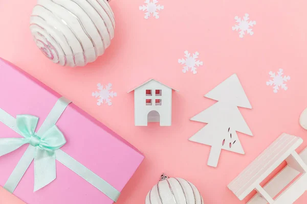 Simplesmente composição mínima objetos de inverno ornamento trenó abeto árvore bola caixa de presente isolado no fundo da moda pastel rosa — Fotografia de Stock