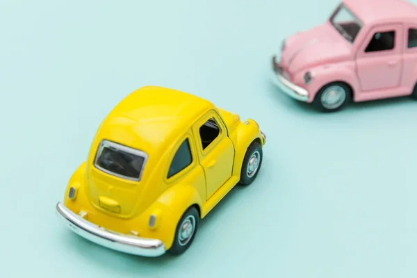 Két sárga rózsaszín vintage retro játék autó elszigetelt kék pasztell színes háttér — Stock Fotó