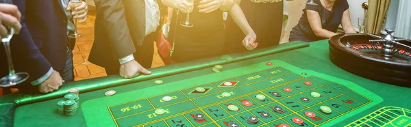 Grupo de personas detrás de la mesa de juego de ruleta en banner de casino de lujo — Foto de Stock