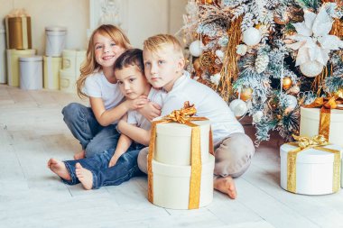 Mutlu bir aile, üç çocuk ve bir kız Noel arifesinde evde oyun oynuyor. Erkek ve kız kardeşler kış dekorasyonuyla aydınlık yatak odasında. Noel için Yeni Yıl