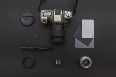 DSR kamera sistemi olan fotoğrafçı işyeri, kamera temizleme seti, siyah masa arka planında lens ve kamera aksesuarı. Hobi seyahat fotoğraf konsepti Düz görünüm kopya alanı yatıyordu