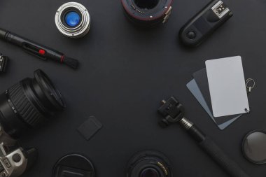 DSLR kamera sistemi, kamera Temizleme Kiti, koyu siyah masa arka planda objektif ve kamera aksesuarı ile fotoğrafçı çalışma alanı