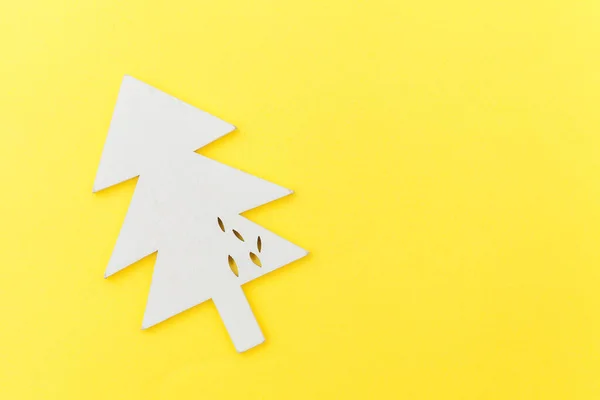 Eenvoudige minimale samenstelling winter objecten ornament dennenboom geïsoleerd op gele trendy achtergrond — Stockfoto