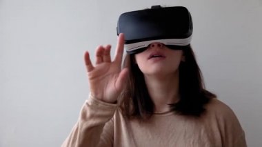 Beyaz arka planda sanal gerçeklik gözlüğü başlığı takan genç kadın gülümse. Sanal gerçeklik gözlüğü takan akıllı telefon. Teknoloji, simülasyon, yüksek teknoloji, video oyunu konsepti