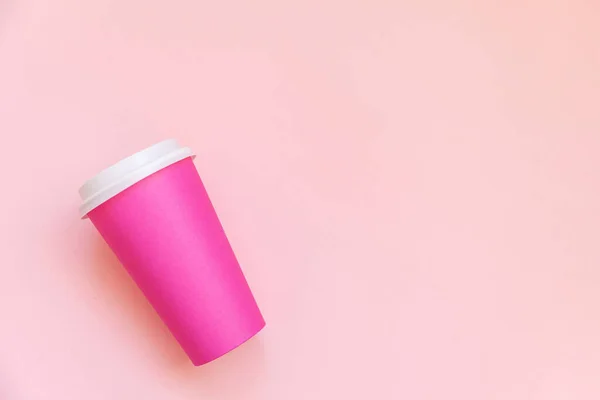 Simplesmente plana leigos design rosa papel xícara de café no pastel rosa colorido fundo da moda — Fotografia de Stock