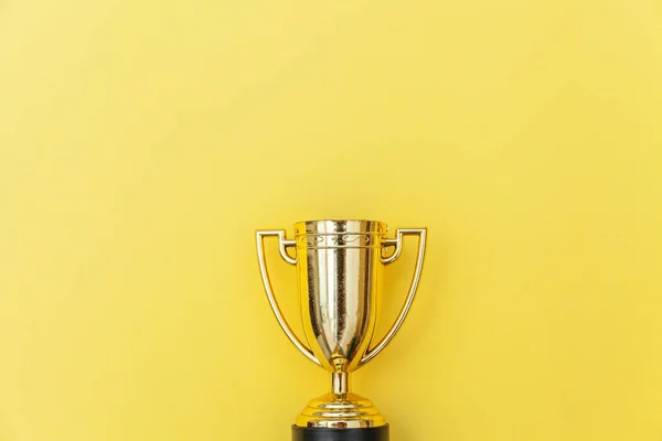 Winner or champion gold trophy cup isolated on yellow colorful background — Stock Photo, Image