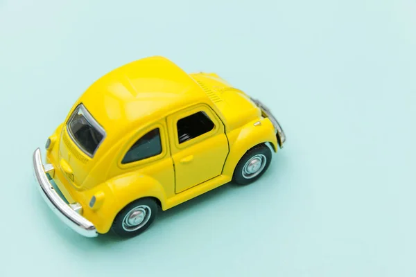 Gelbes Retro-Spielzeugauto isoliert auf blauem pastellfarbenem Hintergrund — Stockfoto