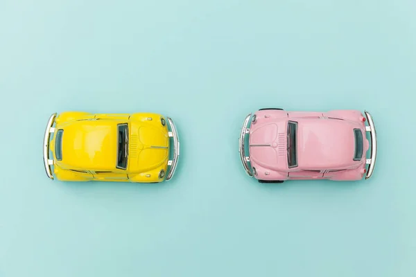 Două galben roz vintage retro jucărie mașină izolat pe fundal albastru pastel colorat — Fotografie, imagine de stoc