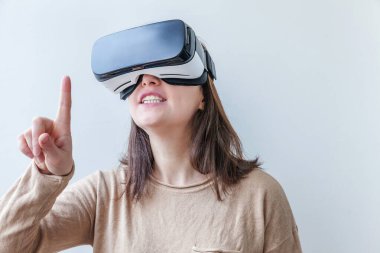 Beyaz arka planda sanal gerçeklik gözlüğü başlığı takan genç kadın gülümse. Sanal gerçeklik gözlüğü takan akıllı telefon. Teknoloji, simülasyon, yüksek teknoloji, video oyunu konsepti.