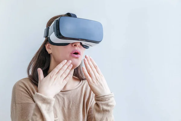 Sonríe mujer joven usando realidad virtual gafas VR casco auriculares sobre fondo blanco. Smartphone con gafas de realidad virtual. Tecnología, simulación, alta tecnología, concepto de videojuego. — Foto de Stock