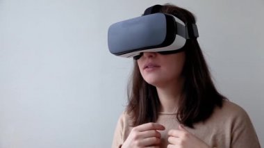 Beyaz arka planda sanal gerçeklik gözlüğü başlığı takan genç kadın gülümse. Sanal gerçeklik gözlüğü takan akıllı telefon. Teknoloji, simülasyon, yüksek teknoloji, video oyunu konsepti.