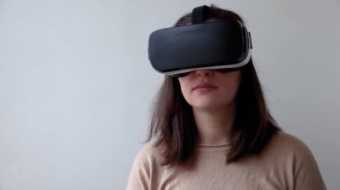 Beyaz arka planda sanal gerçeklik gözlüğü başlığı takan genç kadın gülümse. Sanal gerçeklik gözlüğü takan akıllı telefon. Teknoloji, simülasyon, yüksek teknoloji, video oyunu konsepti.