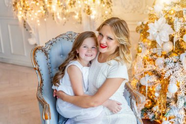 Anne ve kızı evde Noel ağacı yakınında oynarken dinlenmek