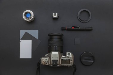 DSR kamera sistemi olan fotoğrafçı işyeri, kamera temizleme seti, siyah masa arka planında lens ve kamera aksesuarı. Hobi seyahat fotoğraf konsepti Düz görünüm kopya alanı yatıyordu