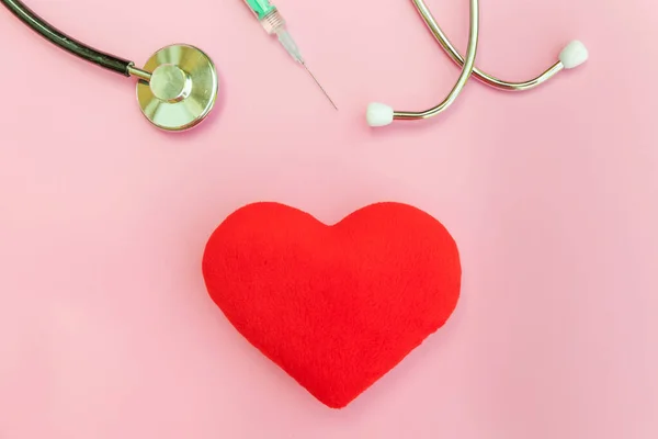 Medicine equipment stethoscope or phonendoscope syringe and red heart isolated on trendy pastel pink background — Stock Photo, Image