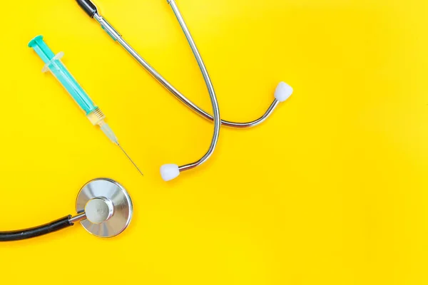 Geneeskunde apparatuur stethoscoop of phonendoscoop en spuit geïsoleerd op trendy gele achtergrond — Stockfoto