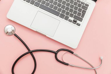 Pembe arka plan üzerinde izole Stetoskop klavye dizüstü bilgisayar. Modern tıbbi Bilgi teknolojisi ve sofware gelişmeler kavramı. Bilgisayar ve gadget tanılama ve onarım