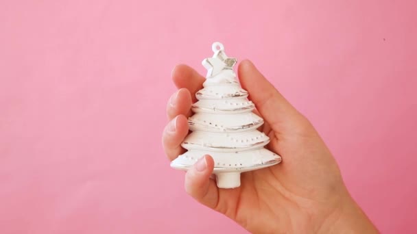 Diseño simplemente minimalista mujer mujer mano celebración Navidad ornamento abeto aislado en rosa pastel colorido fondo de moda — Vídeos de Stock