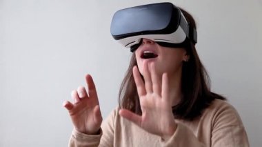 Beyaz arka planda sanal gerçeklik gözlüğü başlığı takan genç kadın gülümse. Sanal gerçeklik gözlüğü takan akıllı telefon. Teknoloji, simülasyon, yüksek teknoloji, video oyunu konsepti