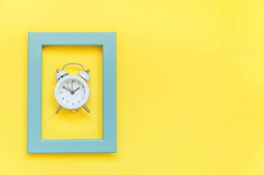 Sarı renkli trendy arka plan izole mavi çerçeve içinde zil çift çan vintage çalar saat. Dinlenme saatleri günaydın sabahları uyanık kavramı uyanmak. Düz lay üst görünüm kopyalama alanı