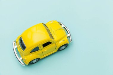 Mavi pastel renkli arka planda izole edilmiş sarı antika oyuncak arabalı basit bir tasarım. Otomobil ve ulaşım sembolü. Şehir trafiği konsepti. Metin için alanı kopyala