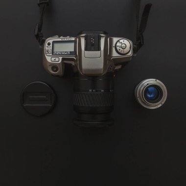 Karanlık masa arka planında DSR kamera sistemi ve lensleri olan fotoğrafçı işyeri. Hobi seyahat fotoğrafçılık konsepti. Düz görünüm kopyalama alanı