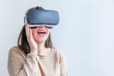 Beyaz arka planda sanal gerçeklik gözlüğü başlığı takan genç kadın gülümse. Sanal gerçeklik gözlüğü takan akıllı telefon. Teknoloji, simülasyon, yüksek teknoloji, video oyunu konsepti.