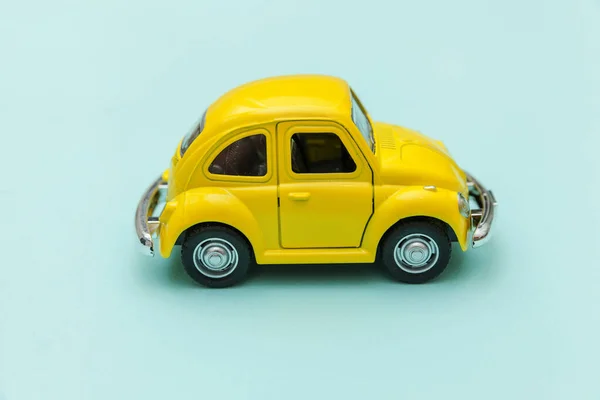 Amarelo vintage retro brinquedo carro isolado em azul pastel colorido fundo — Fotografia de Stock