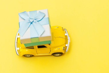 Sadece sarı antika oyuncak araba tasarımı. Moda sarı arka planda izole edilmiş çatıda hediye kutusu dağıtımı. Noel, yeni yıl doğum günü, Sevgililer Günü, hediye romantik konsept