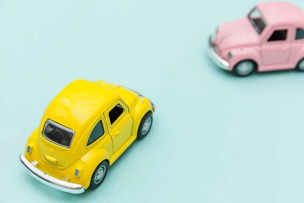 Zwei gelb rosa vintage retro Spielzeugauto isoliert auf blauem pastellfarbenem Hintergrund — Stockfoto