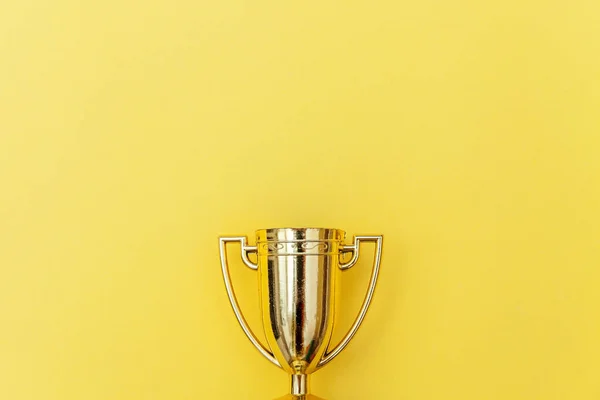 Győztes vagy bajnok arany trófea kupa elszigetelt sárga színű háttér — Stock Fotó