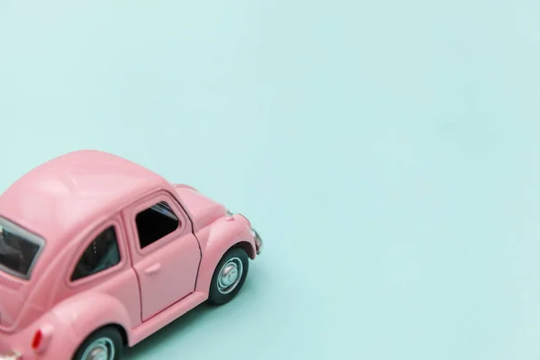 Pink vintage retro toy car isolated on blue pastel colorful background