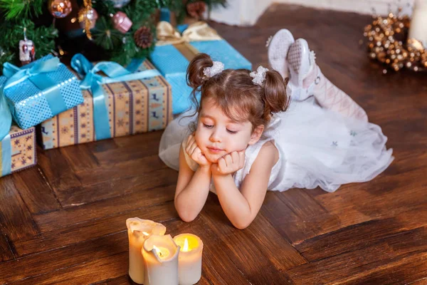 Nieuwjaar 2020 Vrolijk kerstfeest. Meisje met geschenkdoos bij kerstboom op kerstavond december thuis. Jong kind in de slaapkamer met winterdecoratie. Tijd voor een feestelijk concept — Stockfoto
