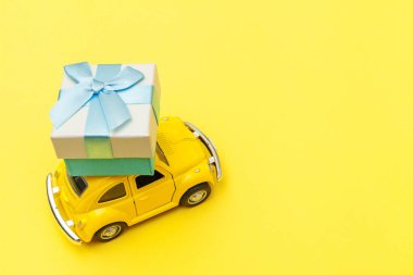 Sadece sarı antika oyuncak araba tasarımı. Moda sarı arka planda izole edilmiş çatıda hediye kutusu dağıtımı. Noel, yeni yıl doğum günü, Sevgililer Günü, hediye romantik konsept