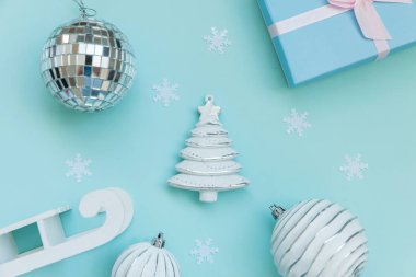 Basit bir kompozisyon kış nesneleri süslemesi köknar ağacı topu hediye kutusu mavi pastel arka planda izole