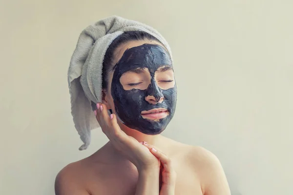 Mujer aplicando máscara negra nutritiva en la cara —  Fotos de Stock