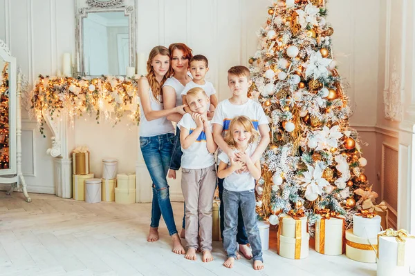 Счастливая семейная мама и пятеро детей украшают елку в канун Рождества дома. Мама дочерей сыновей в светлой комнате с зимней отделкой. Рождественский Новый Год для празднования — стоковое фото