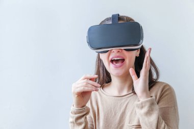 Beyaz arka planda sanal gerçeklik gözlüğü başlığı takan genç kadın gülümse. Sanal gerçeklik gözlüğü takan akıllı telefon. Teknoloji, simülasyon, yüksek teknoloji, video oyunu konsepti.