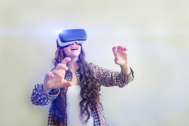 Beyaz arka planda sanal gerçeklik Vr gözlük kask kulaklık kullanarak giyen smile genç kadın. Sanal gerçeklik gözlüğü ile akıllı telefon kullanımı