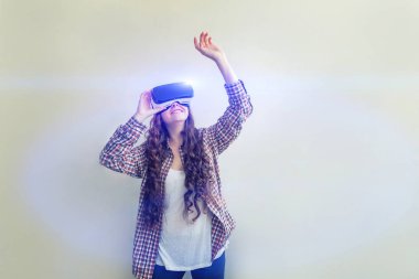 Beyaz arka planda sanal gerçeklik Vr gözlük kask kulaklık kullanarak giyen smile genç kadın. Sanal gerçeklik gözlüğü ile akıllı telefon kullanımı
