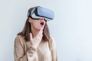 Beyaz arka planda sanal gerçeklik gözlüğü başlığı takan genç kadın gülümse. Sanal gerçeklik gözlüğü takan akıllı telefon. Teknoloji, simülasyon, yüksek teknoloji, video oyunu konsepti.
