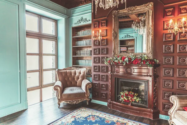 Interior clássico de luxo da biblioteca doméstica. Sala de estar com estante, livros, cadeira de braço, sofá e lareira — Fotografia de Stock