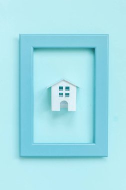 Sadece mavi pastel renkli trendy arka plan izole mavi çerçeve minyatür beyaz oyuncak ev ile tasarım