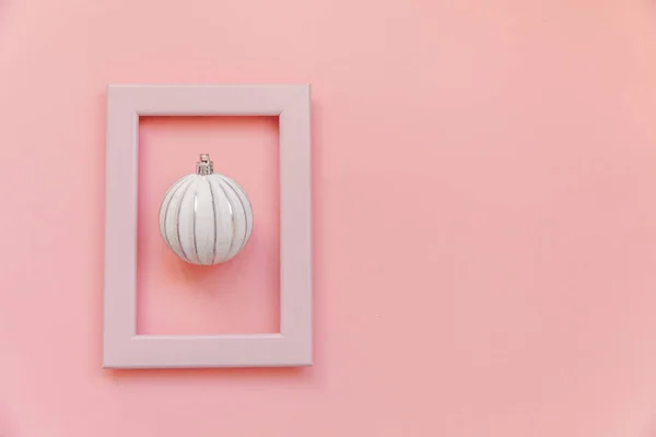 Просто минимальная композиция зимних объектов украшения мяч в розовой рамке изолированы на розовый пастельный модный фон — стоковое фото