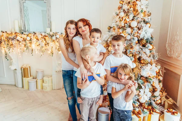 Ευτυχισμένη οικογενειακή μητέρα και πέντε παιδιά στολίζουν το χριστουγεννιάτικο δέντρο την παραμονή των Χριστουγέννων στο σπίτι. Mom κόρες γιους στο φως δωμάτιο με διακόσμηση το χειμώνα. Χριστούγεννα Πρωτοχρονιά για γιορτή — Φωτογραφία Αρχείου