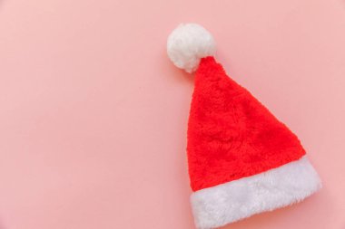 Noel Baba 'nın pembe renkli arka planda izole edilmiş en az tasarım Noel Baba şapkası. Noel, yeni yıl kutlamaları için aralık zamanı. Düz görünüm kopyalama alanı