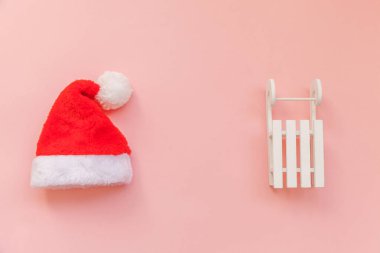 Noel Baba 'nın pembe renkli arka planda izole edilmiş küçük bir Noel Baba şapkası. Noel, yeni yıl kutlamaları için aralık zamanı. Düz görünüm kopyalama alanı