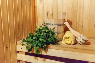 Finlandiya sauna saunasında geleneksel sauna aksesuarları ve huş ağacı süpürgesi havlusuyla ilgili detaylar. Geleneksel eski Rus hamamı SPA konsepti. Rahatlayın köy banyosu konsepti