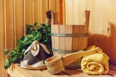 İçişleri, geleneksel sauna aksesuarları, süpürge kepçesi kepçeli şapka havlusuyla Finlandiya sauna sauna saunası detaylarını anlatıyor. Geleneksel eski Rus hamamı SPA konsepti. Rahatlayın köy banyosu konsepti